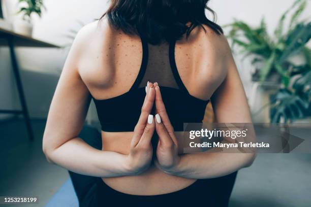girl in uniform meditates in lotus position at home. - escapula fotografías e imágenes de stock
