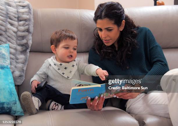 Ambar Marcus reads a story to Aidan Marcus during the Marcus family&apos;s visit at the home of the toddler&apos;s grandparents.