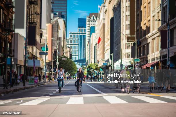 mid adult male bikers cycling in downtown car-free zone - downtown la stock pictures, royalty-free photos & images