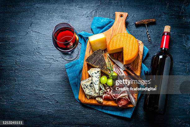 fondo aperitivo: quesos, jamón serrano y vino tinto sobre mesa oscura. copiar espacio - jamón serrano fotografías e imágenes de stock
