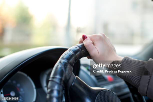 closeup image of  woman driver in car behind steering wheel - auto cockpit bildbanksfoton och bilder
