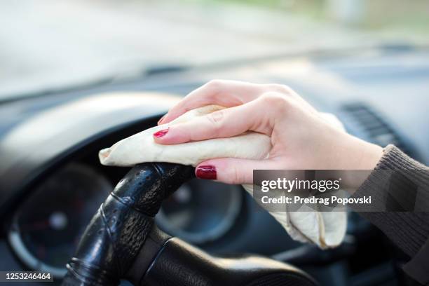 coronavirus paranoia concept , woman cleaning steering wheel of car - cleaning inside of car stock pictures, royalty-free photos & images