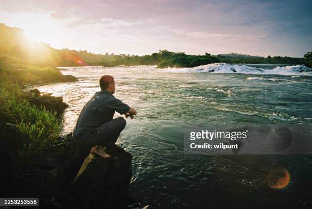 giovane che fissa la sorgente del fiume nilo - sorgente foto e immagini stock
