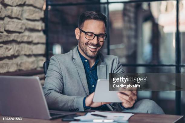 homme d’affaires utilisant la tablette numérique - homme d'affaires photos et images de collection