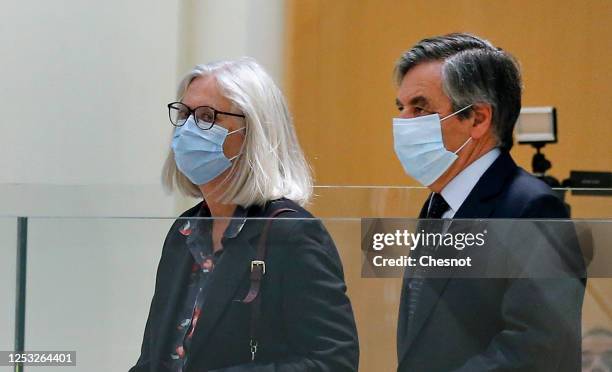 Former French prime minister Francois Fillon and his wife Penelope Fillon, wearing protective face masks, arrive for the verdict in their trial over...