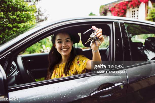 cheerful young woman showing the keys of her new car - rijden een motorvoertuig besturen stockfoto's en -beelden
