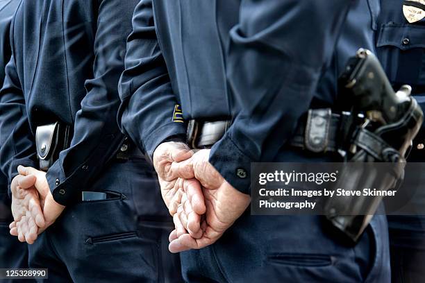 officers standing with hands behind - polizist stock-fotos und bilder