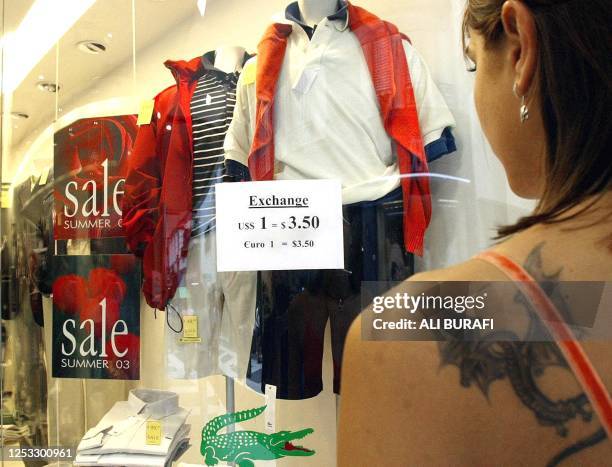 Tourist looks through the window of a clothing store that is being sold at an exchange rate of 3.50 pesos to 1 dollar, a higher quote then in...