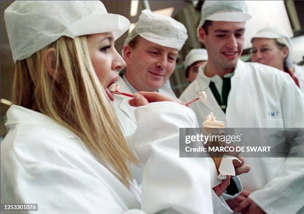 Argentina's Maxima Zorreguieta tastes her self-tapped soft-ice, as her fiancee Dutch crownprince Willem-Alexander looks on, in a college for food...