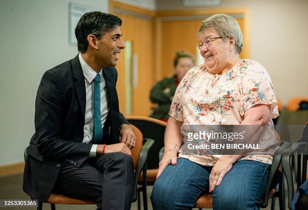 Britain's Prime Minister Rishi Sunak talks with a patient during a visit to a doctor's GP surgery and pharmacy in Weston, southern England on May 9,...