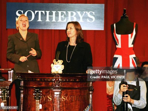 Geri Halliwell former "Ginger Spice" member of the Britain girl group the Spice Girls laughs watched by auctioneer Kerry Taylor, 16 September, after...