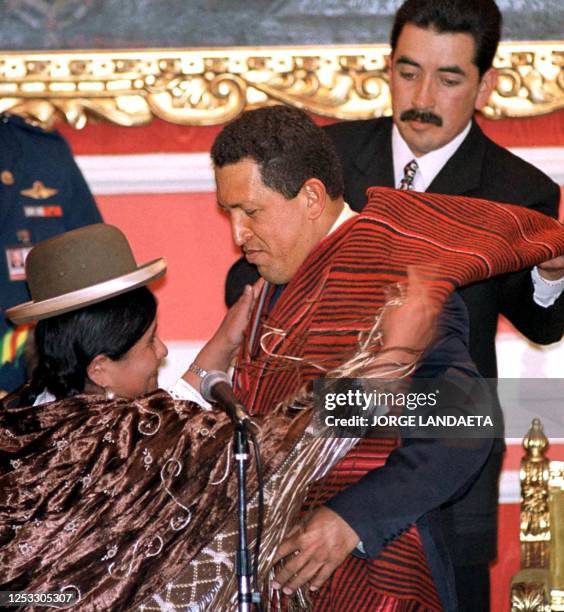 Bolivian craftswoman puts a Aymara dress to Venezuelan President Hugo Chavez Frias with an ursher's help at the mayor's office in La Paz, Bolivia, 29...