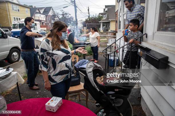 Elementary school teacher Luciana Lira greets baby Neysel, 10 weeks, at a dinner celebrating his three month birthday on June 28, 2020 in Stamford,...