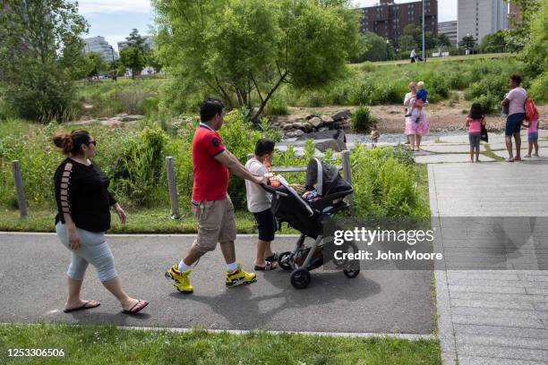 Marvin and Zully walk with their sons Junior and Neysel, 10 weeks, at a park on June 25, 2020 in Stamford, Connecticut. Marvin, Zully and Junior...