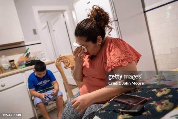 Zully wipes away tears after speaking on the phone with her Covid-sick mother Aurora on June 17, 2020 in Stamford, Connecticut. Aurora, who lives in...