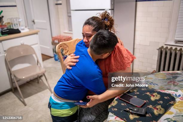 Junior comforts his mother Zully after they spoke on the phone with her Covid-sick mother Aurora on June 17, 2020 in Stamford, Connecticut. Aurora,...