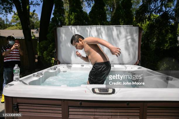 Junior swims in his elementary school teacher Luciana Lira's jacuzzi on May 20, 2020 in Stamford, Connecticut. His Guatemalan immigrant family fell...