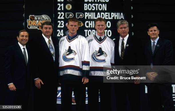 The second overall pick Daniel Sedin, 3rd overall pick Henrik Sedin and Vancouver Canucks general manager Brian Burke poses for a photo during the...