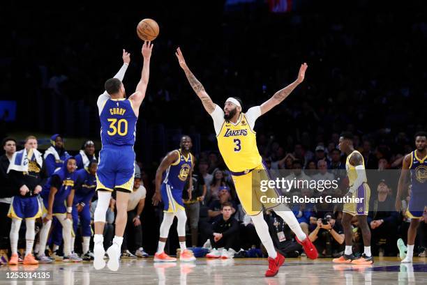 Los Angeles, CA Los Angeles Lakers forward Anthony Davis, right, defends a three-point basket attempt by Golden State Warriors guard Stephen Curry...