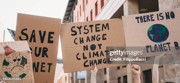 group of people participating in a protest against global warming - climate stock pictures, royalty-free photos & images