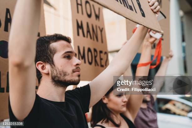 group of people participating in a social protest in the city - social justice concept stock pictures, royalty-free photos & images