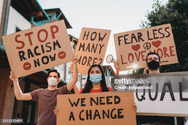 group of people participating in an anti-racism protest - anti racism stock pictures, royalty-free photos & images