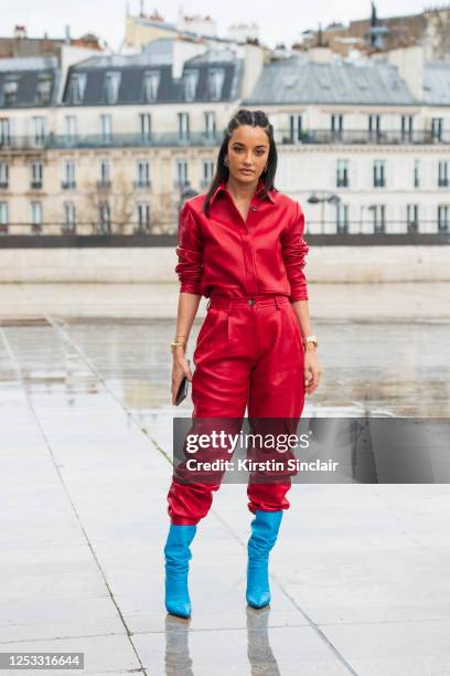 Shoe designer Amina Muaddi wears a Bouguessa shirt and trousers and Amina Muaddi boots on March 02, 2020 in Paris, France.