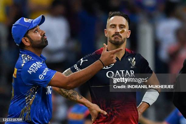 Mumbai Indians' Rohit Sharma tosses the coin as Royal Challengers Bangalore's Faf du Plessis watches during the Indian Premier League Twenty20...