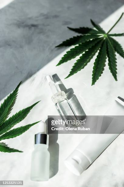 oil in a frosted and transparent glass jars with a pipette and leaves of marijuana - cannabis concentrate stock pictures, royalty-free photos & images