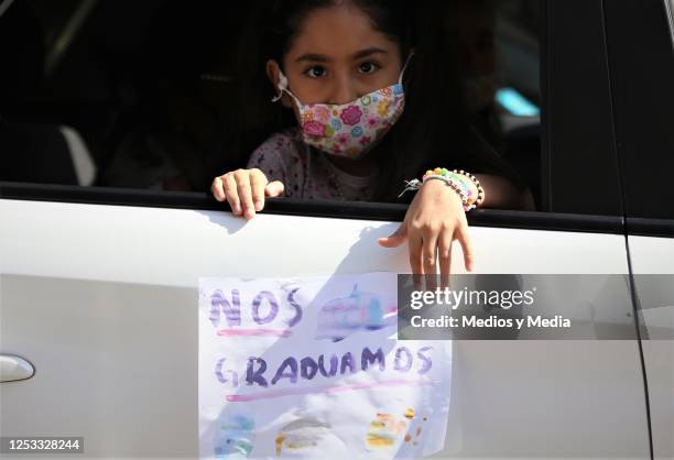 Girl with a face mask shows a sign during graduation from the 'Instituto de Aprendizaje Creativo' on June 29, 2020 in Monterrey, Mexico.