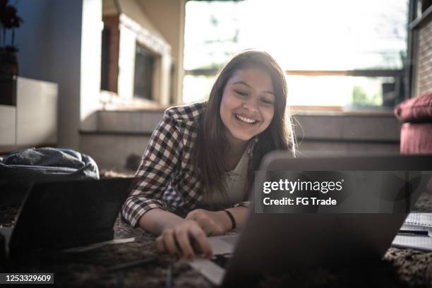 fille d’adolescent étudiant à la maison sur un ordinateur portatif à la maison - 12 13 ans photos et images de collection
