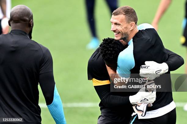 Inter Milan's Cameroonian goalkeeper Andre Onana and Inter Milan's Bosnian forward Edin Dzeko laugh during a training session in Appiano Gentile, on...