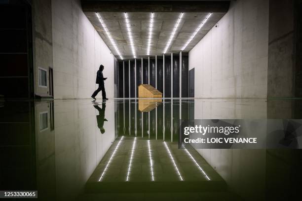 An employee of the CSTB evaluates the wood tiled roof's resistance under the exreme wind and rain conditions at the Jules Verne Climatic Wind Tunnel,...