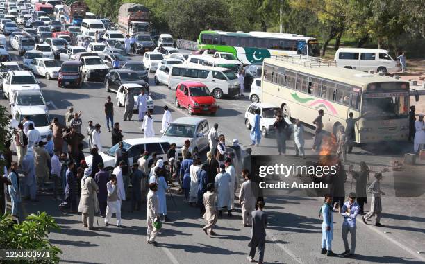 The supporters of Pakistan Tehreek-e-Insaf of block the road by torching tyres during a protest over the arrest of their leader, in Rawalpindi,...