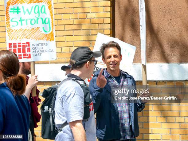 Seth Meyers is seen holding signs in support of the Writers Guild of America strike outside the Silvercup Studios on May 09, 2023 in New York City.