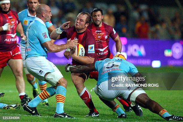 Montpellier' South African hooker Rassie Van-Vuuren is tackled by Perpignan's lock Robins Watchou-Tchale of Cameroon during the French Top 14 rugby...