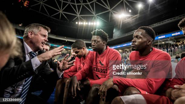 coach giving instructions to basketball team - basketball team work stock pictures, royalty-free photos & images