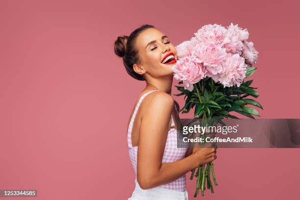 happy young woman holding bouquet of pink flowers - beautiful woman spring stock pictures, royalty-free photos & images