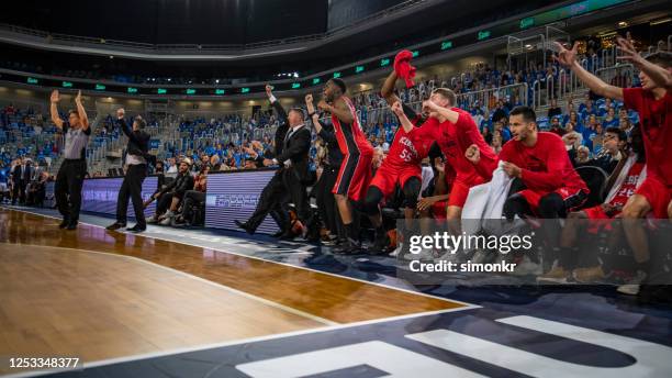 jugadores de baloncesto y entrenador celebrando en la cancha - equipo de baloncesto fotografías e imágenes de stock