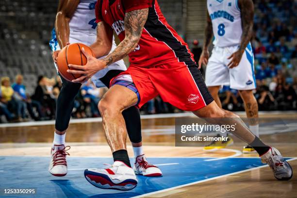 joueurs de basket-ball s’attaquant pour le ballon - competition round photos et images de collection