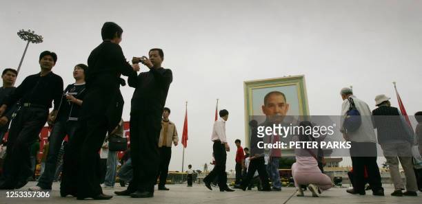 People take pictures in front of a giant portrait of Sun Yat-sen, the founder of modern China, on Tiananmen Square on the eve of Chinese National Day...