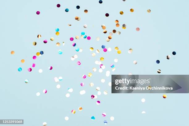 colored confetti flying in the blue sky. are small pieces or streamers of paper, mylar, or metallic material which are thrown at parades and celebrations. - confeti bildbanksfoton och bilder