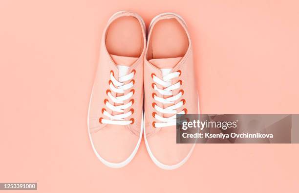 pink girls sneakers (tennis shoes) over a white background - paio foto e immagini stock