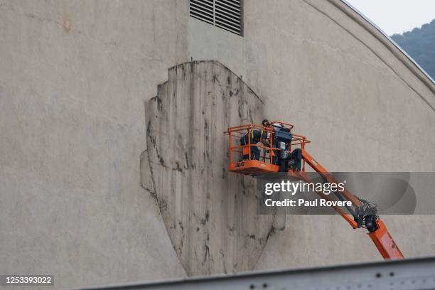 Workers on a cherry picker repair the Warner Bros logo at Warner Brothers Studios on December 14 in Los Angeles, California. The 110-acre main lot...