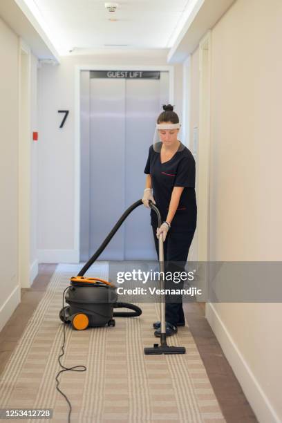 maid vacuuming hotel corridor - housekeeping uniform stock pictures, royalty-free photos & images