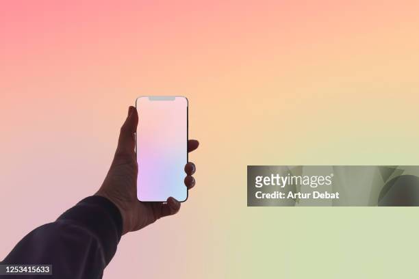 creative picture capturing the colors of sunset sky with mobile phone. - draagbare informatie apparatuur stockfoto's en -beelden