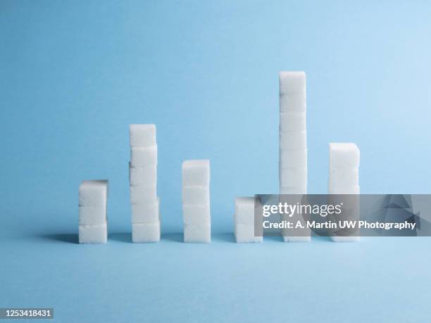 close-up of sugar cubes graph against blue background - glucose chart stock pictures, royalty-free photos & images