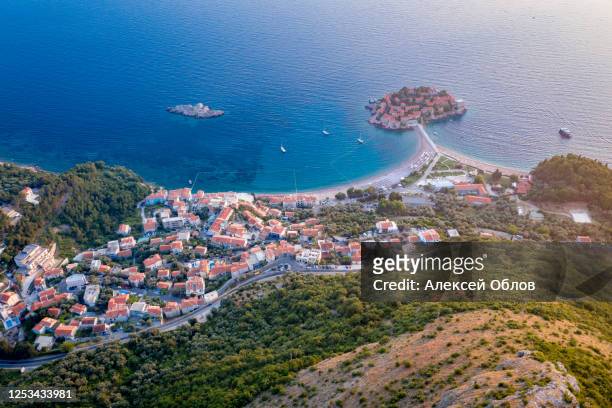 aerial view on sveti stefan island with road and coastal town. montenegro - isthmus stock-fotos und bilder
