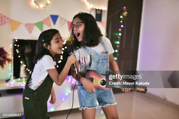 girls performing a song at home - middle childhood stock pictures, royalty-free photos & images