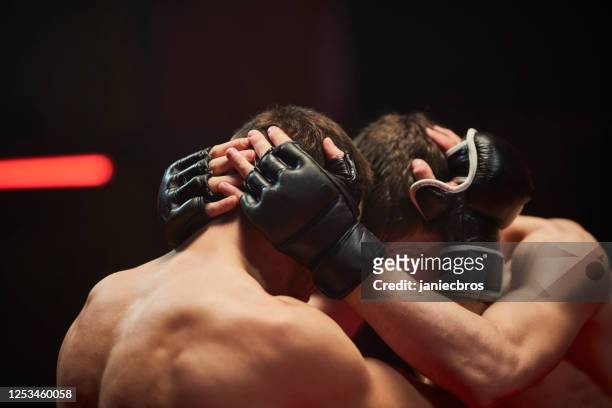 mma fighters throw punches in octagon. close up - octagon box stock pictures, royalty-free photos & images
